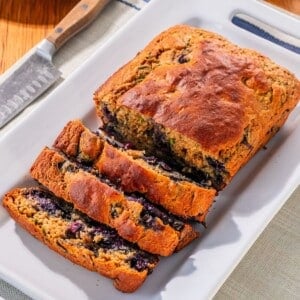 Zucchini blueberry bread sliced on a platter.