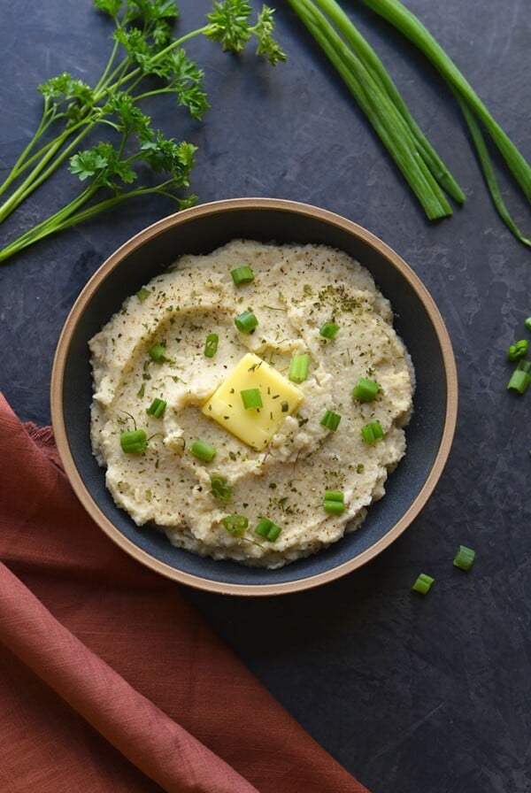 Whole30 Roasted Garlic Cauliflower Mash! These creamy "potatoes" are a healthy low carb alternative to mashed potatoes. Made with simple, real food ingredients with the same consistency as real potatoes.