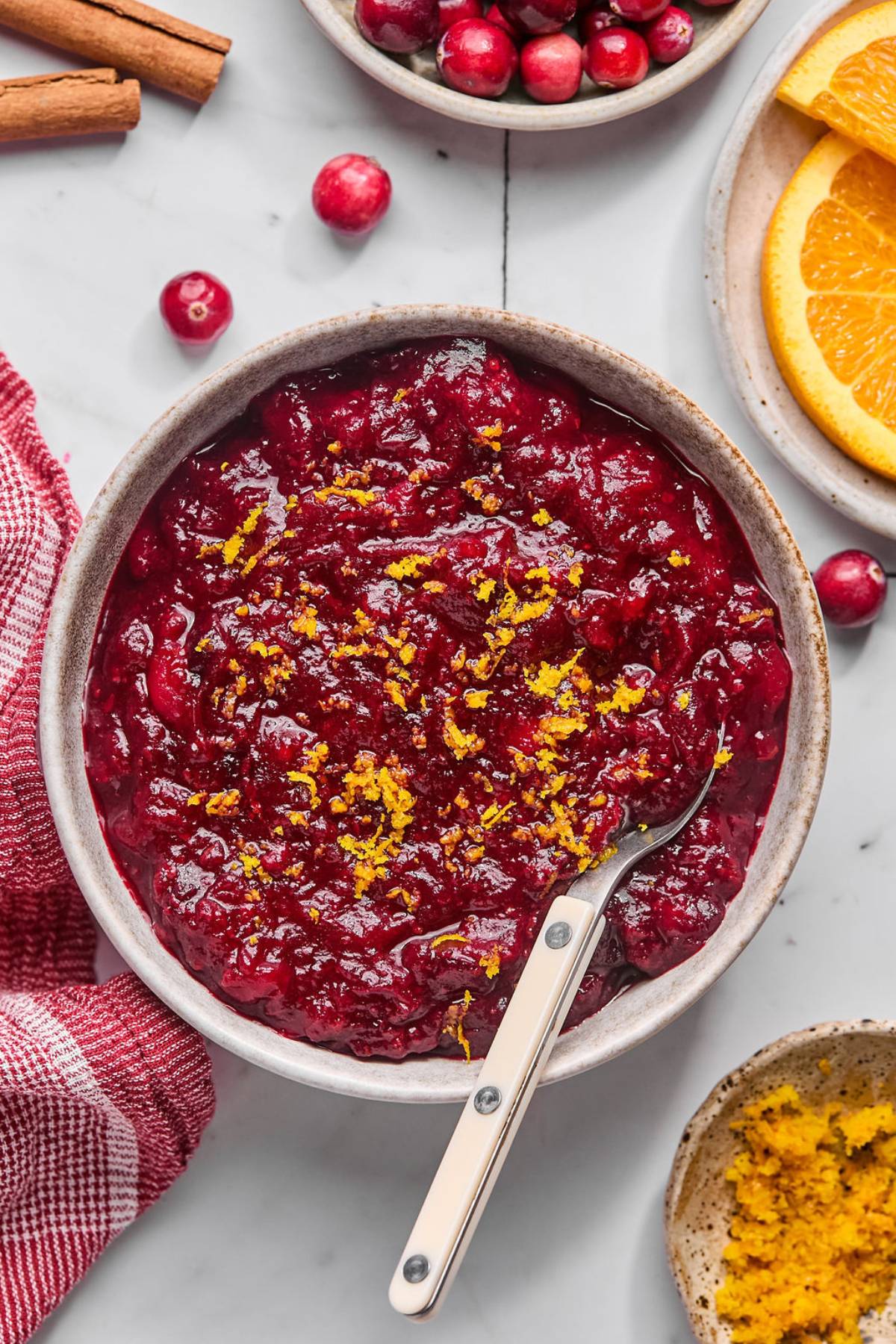 A bowl of sugar free cranberry sauce on the table topped with orange zest.