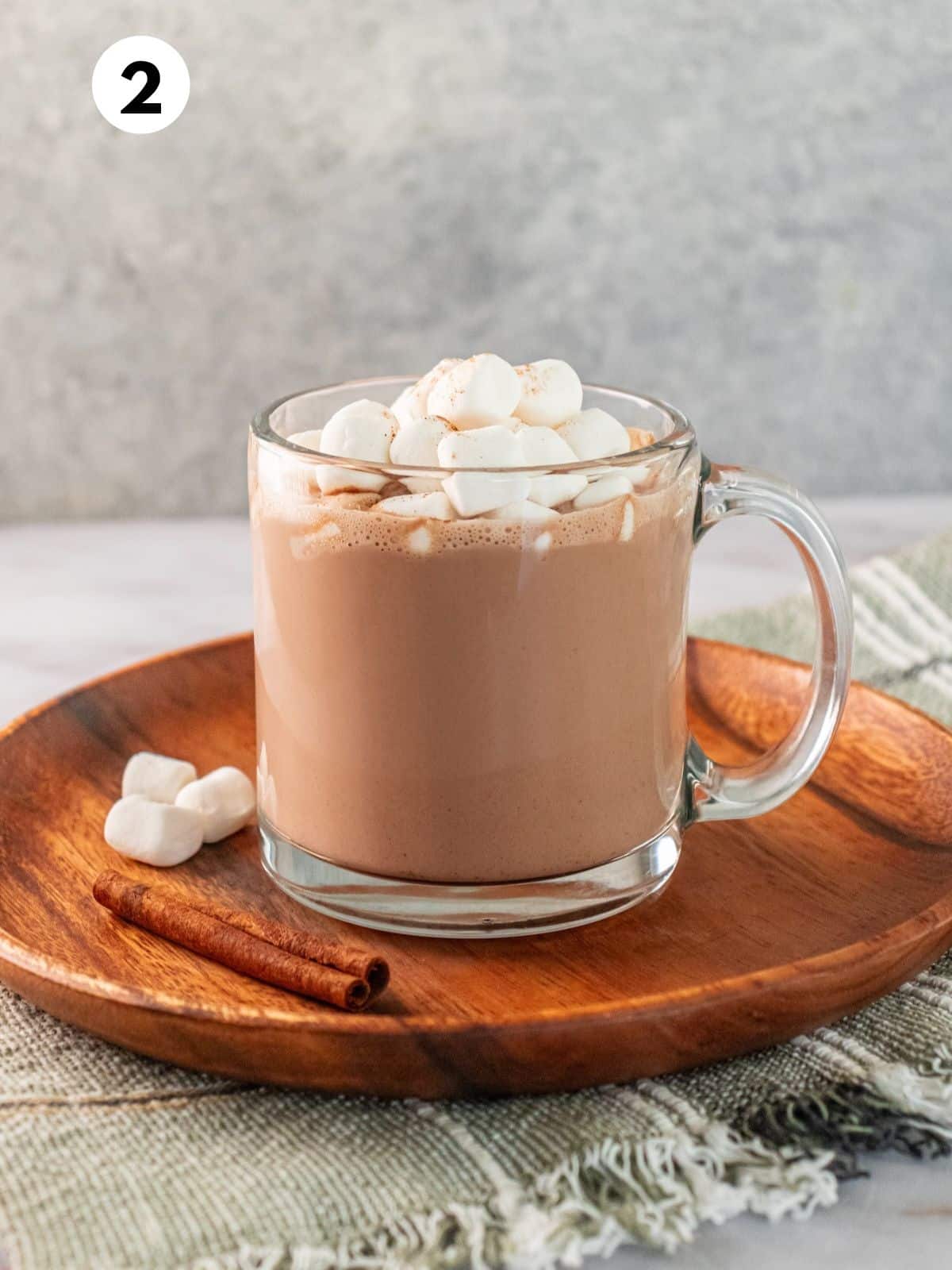 A mug full of peanut butter hot chocolate with marshmallows on top.