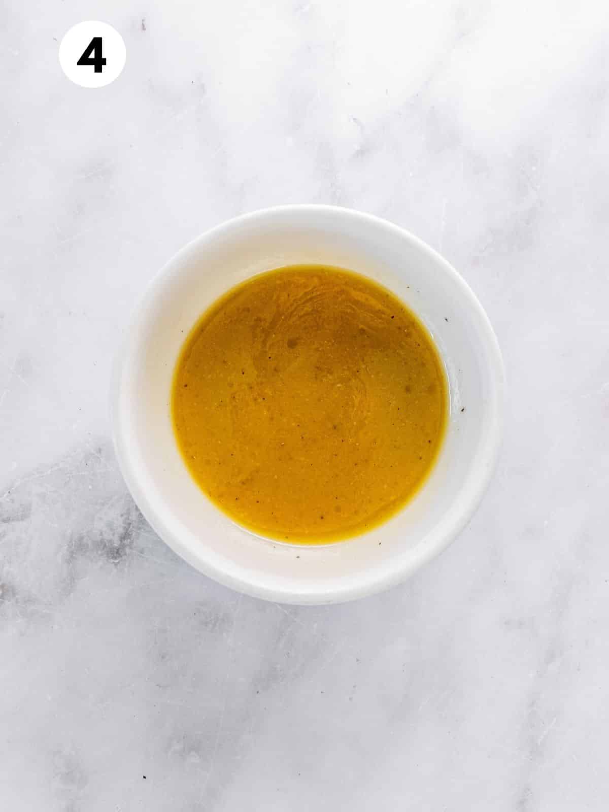 Salad dressing in a small white bowl.
