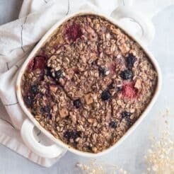 Protein baked oats with mixed berries in a baking dish on the table ready to serve.