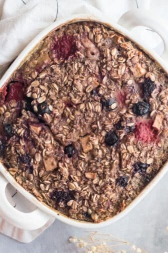 Protein baked oats with mixed berries in a baking dish on the table ready to serve.