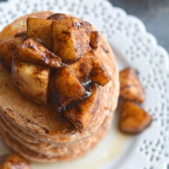 Apple Cinnamon Greek Yogurt Pancakes! Light, fluffy whole grain pancakes topped with caramelized apples. These lightened up pancakes are gluten free and make an irresistible fall breakfast! Gluten Free + Low Calorie