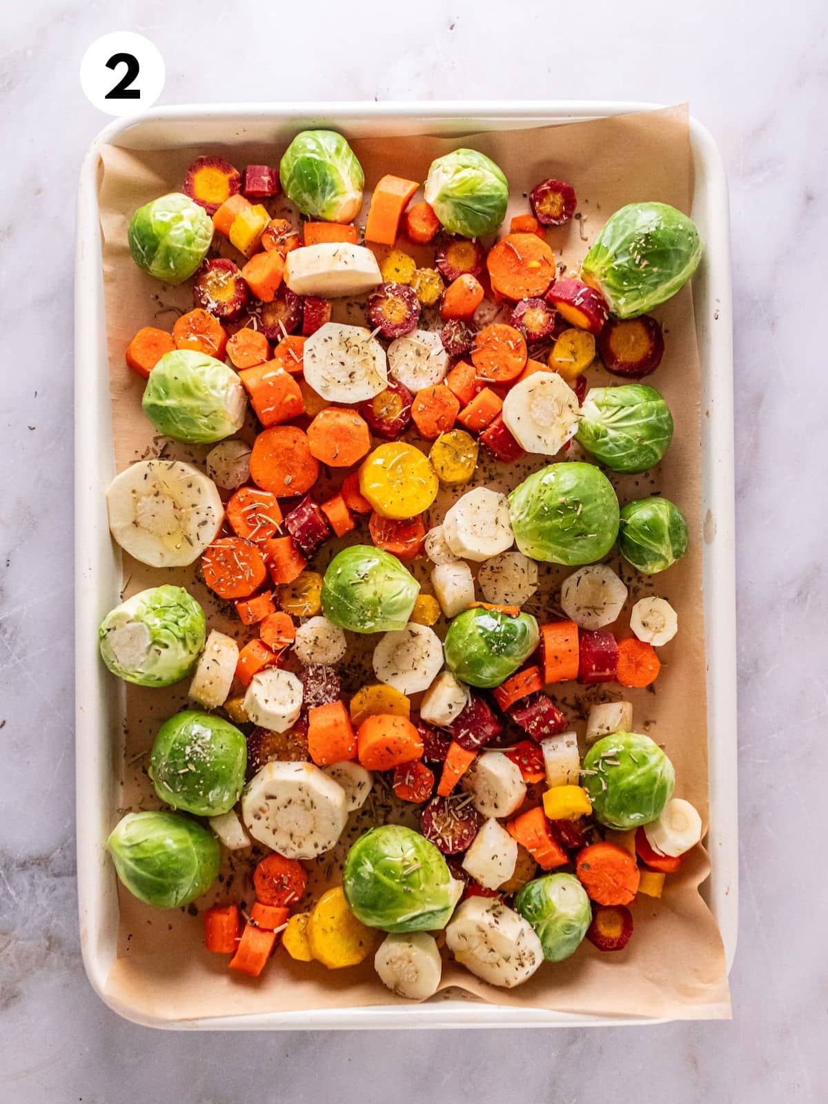 Seasoned roasted winter vegetables on a baking sheet.