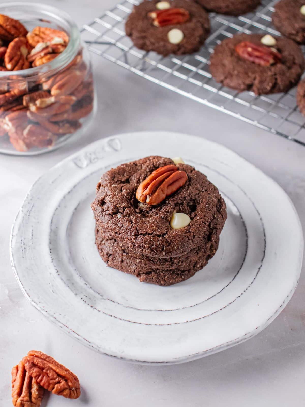 A white chocolate pecan cookie on a plate.