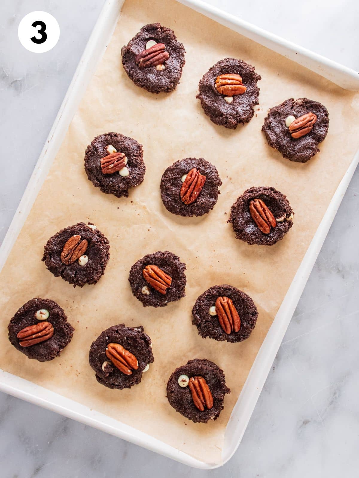 Unbaked cookies on a cookie sheet.