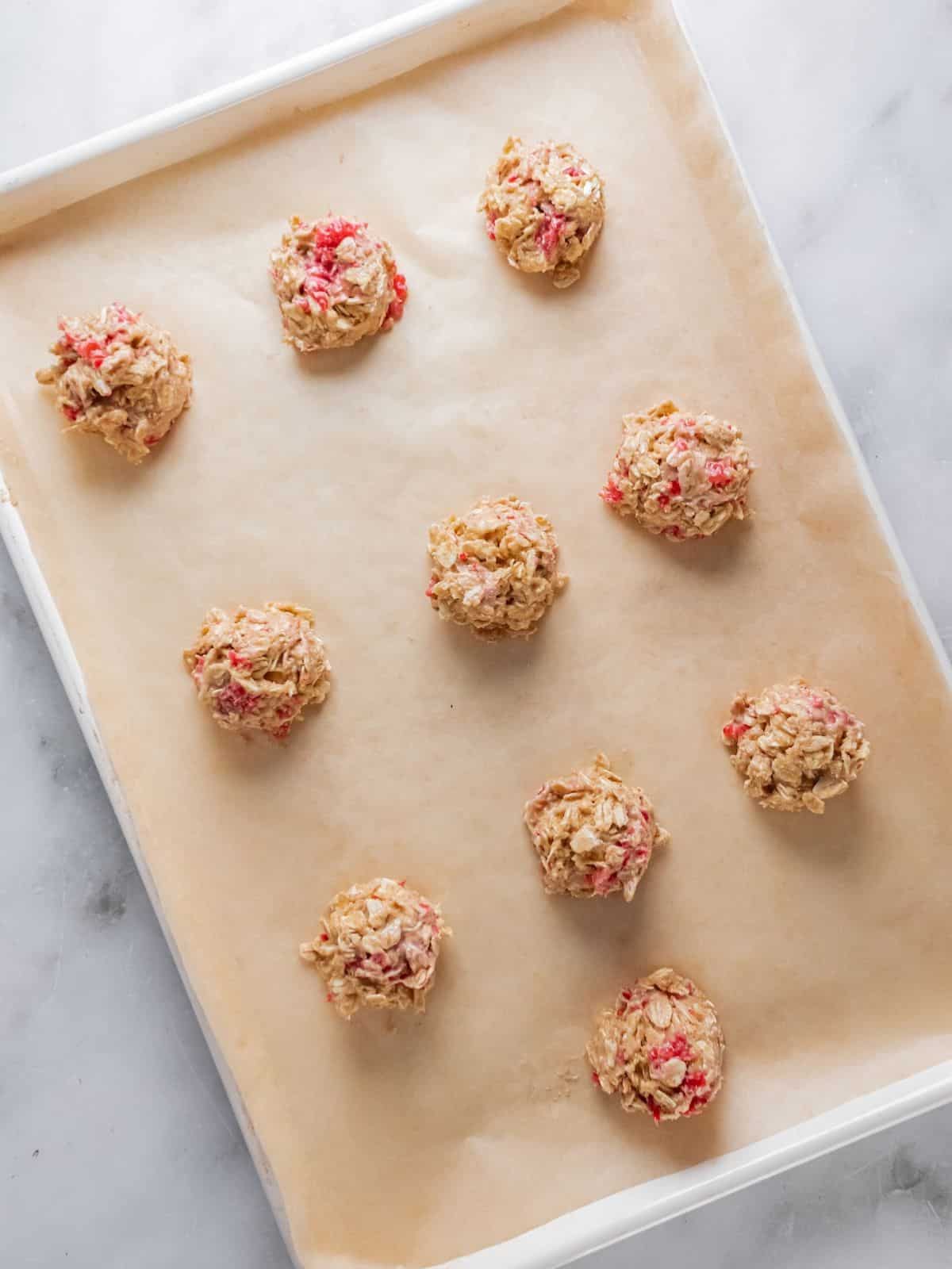 Scooped out cookies placed on a baking sheet.