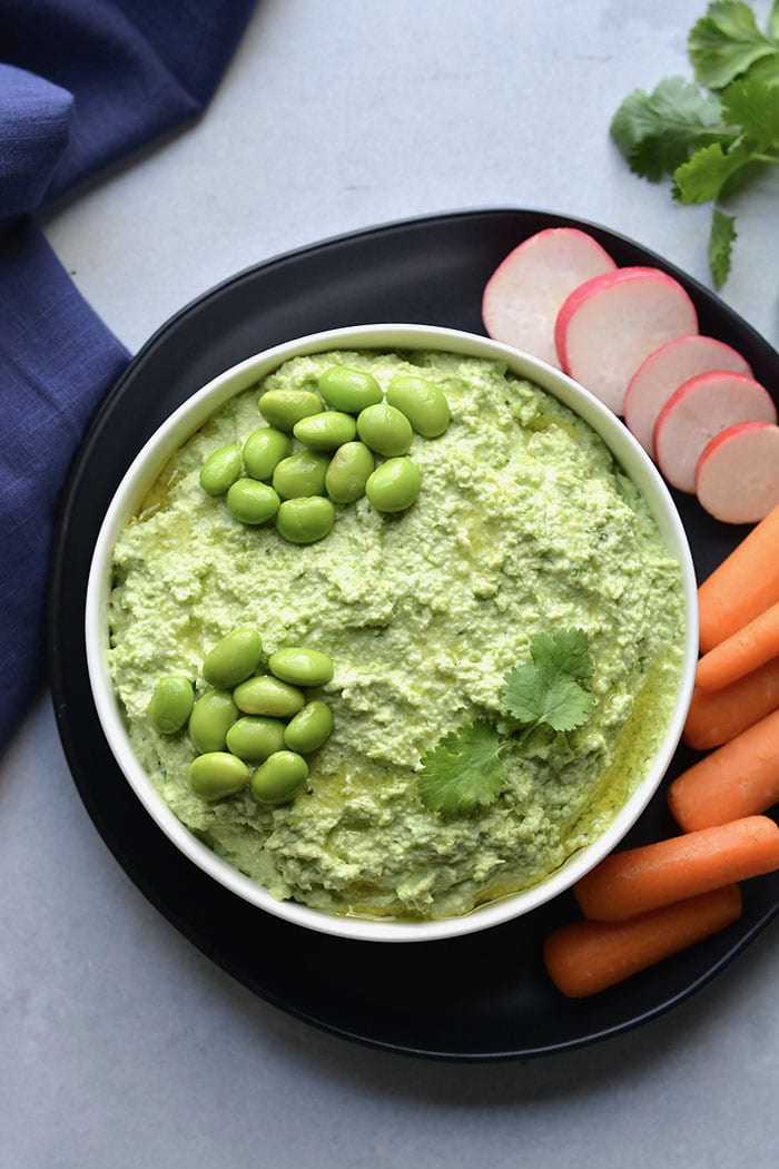 Edamame Hummus made with 4 ingredients. A simple, high protein snack made in a blender with Greek yogurt and fresh herbs. A healthy, gluten free protein packed snack for any day of the week! Gluten Free + Low Calorie