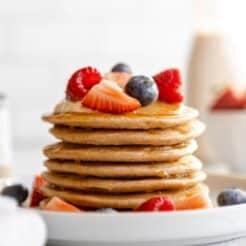 A stack of cottage cheese protein pancakes on the table with berries.