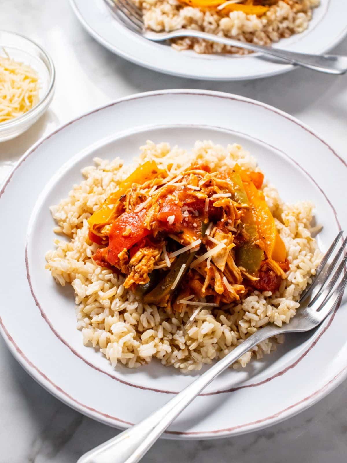 Crockpot chicken and peppers on a white plate.