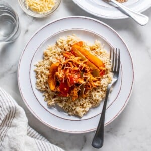 Crockpot chicken and peppers on a white plate.