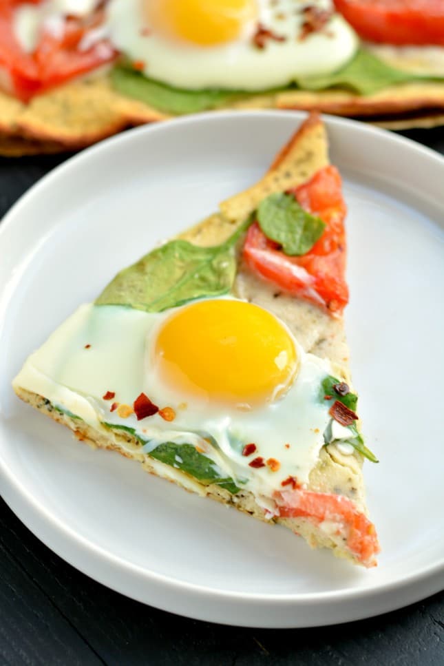 Wake up to Paleo Breakfast Pizza! Made with a simple coconut egg crust and topped with fresh veggies and cracked eggs, this is a perfect, easy meal for any time of day!
