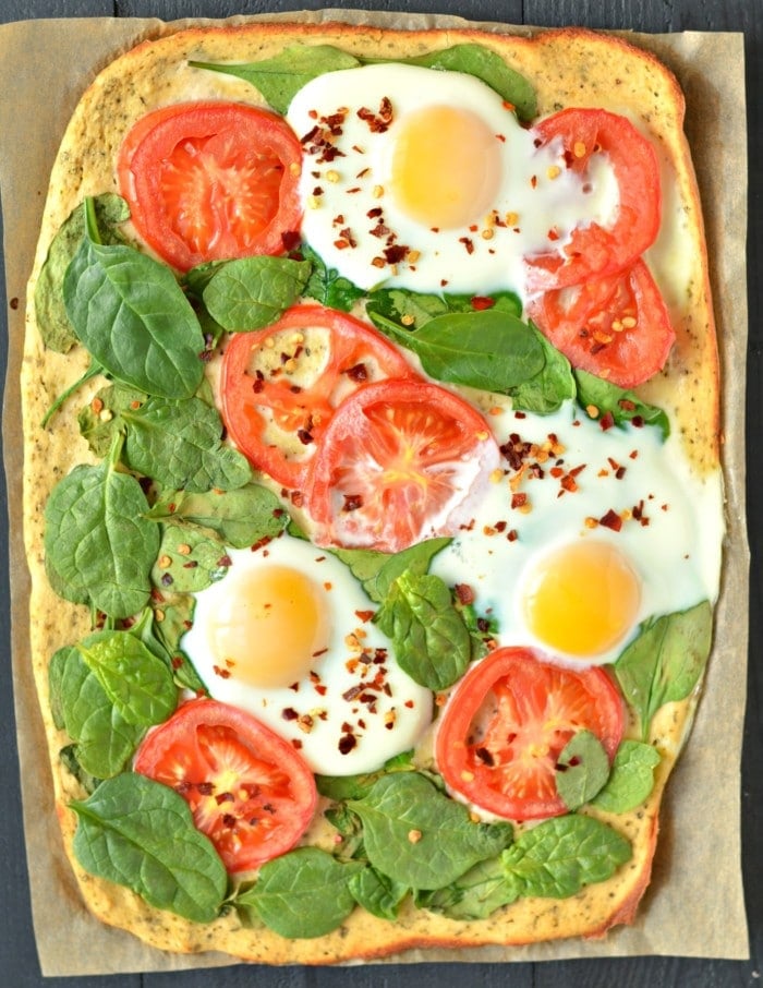 Wake up to Paleo Breakfast Pizza! Made with a simple coconut egg crust and topped with fresh veggies and cracked eggs, this is a perfect, easy meal for any time of day!