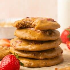 A stack of strawberry oatmeal cookies with the one on top missing a bite.