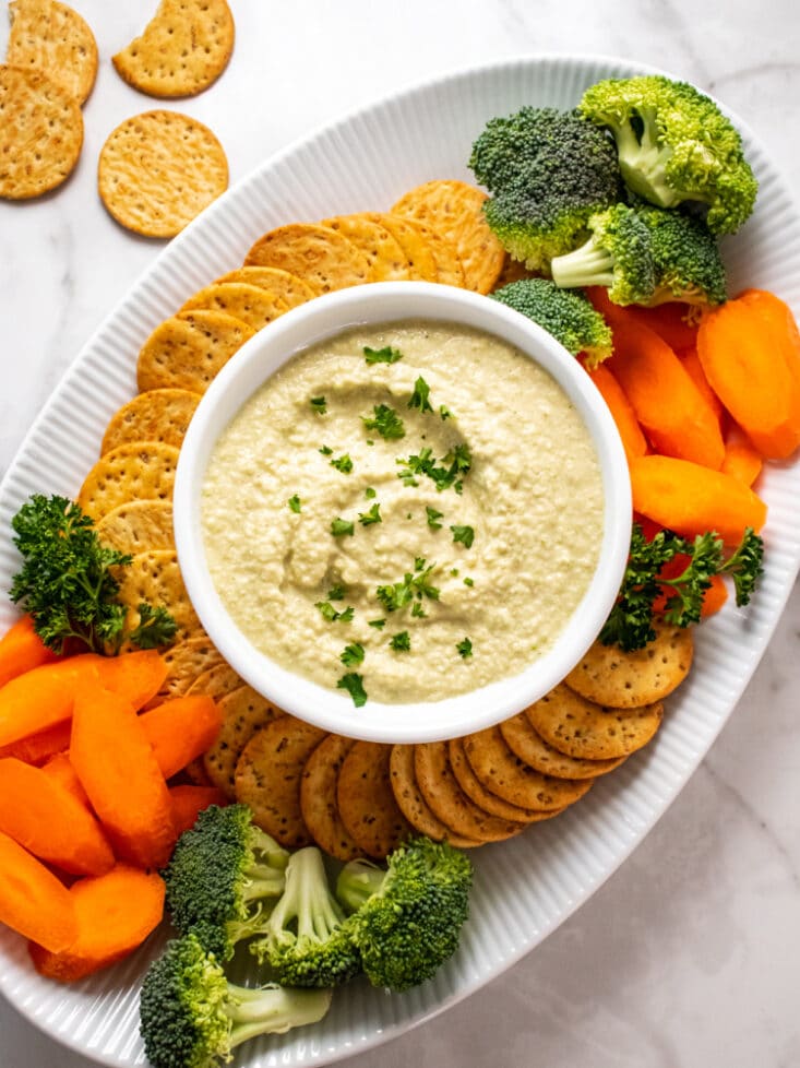 hummus on a platter with veggies and crackers