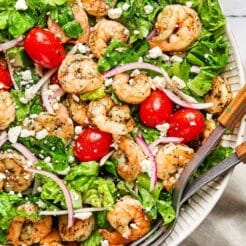 Greek shrimp salad served in a white bowl.