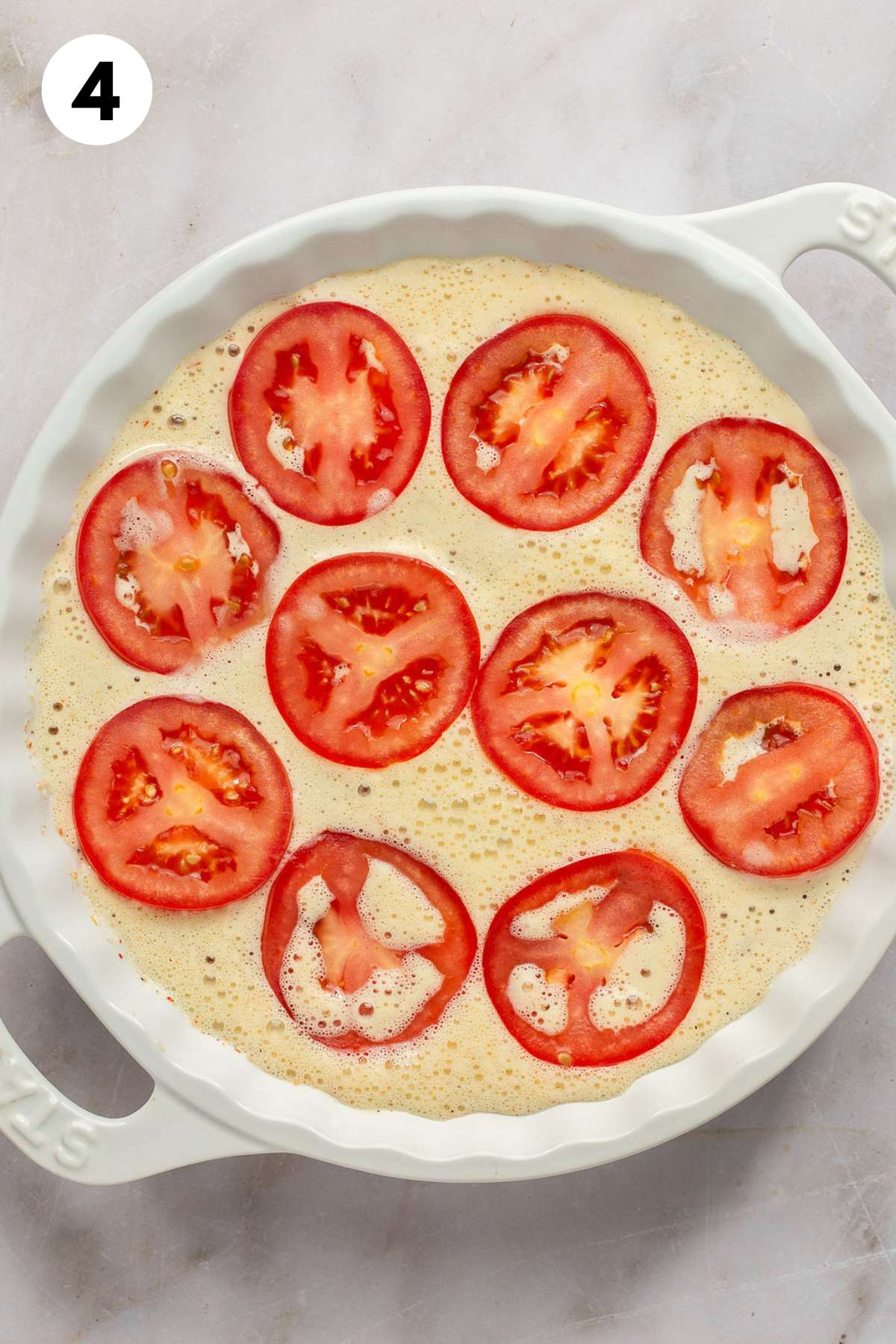 Egg mixture poured into the dish and topped with tomato slices.