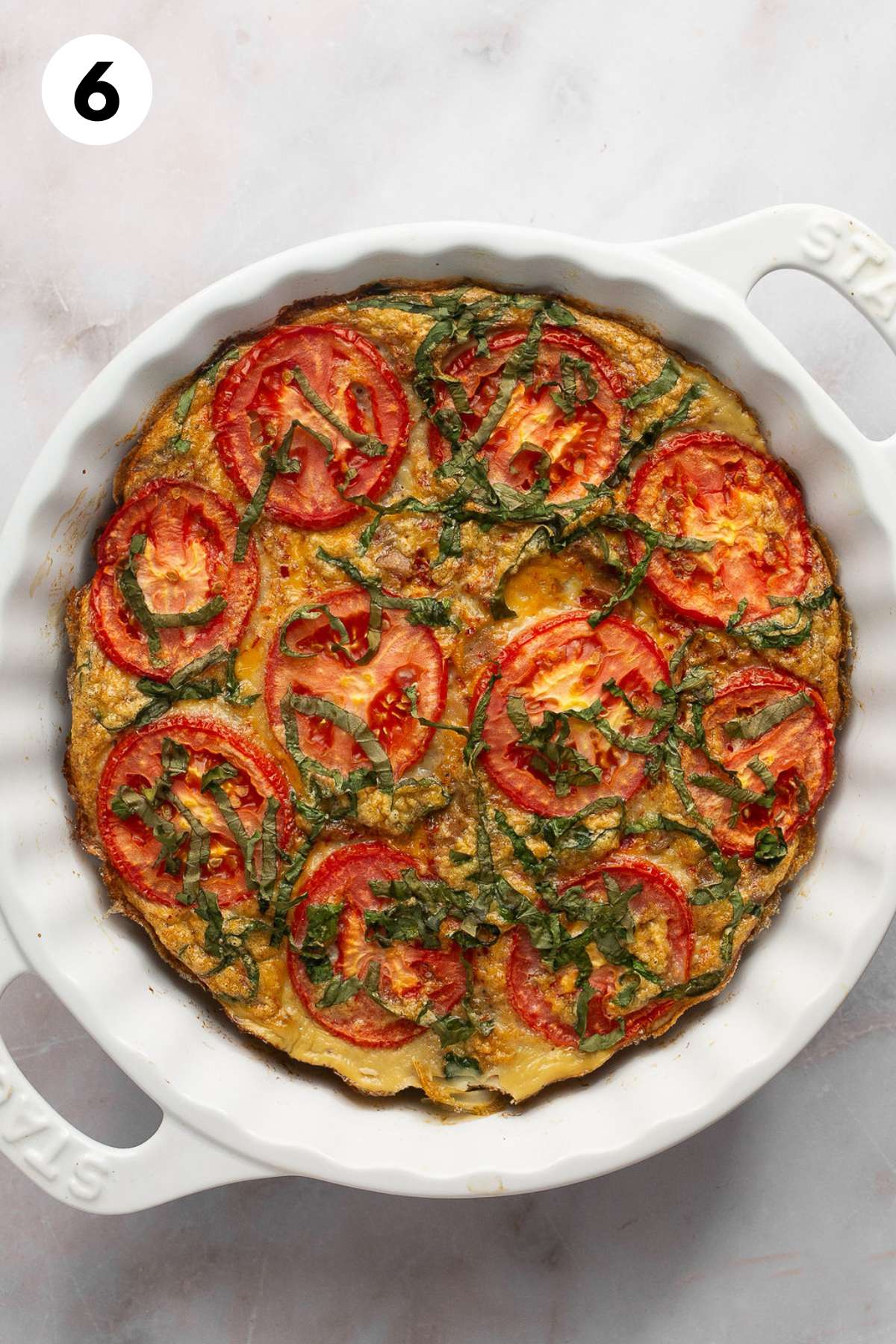 Sausage casserole baked in a round casserole dish.