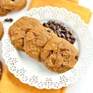 A stack of gluten free pumpkin chocolate chip cookies with a bite missing from the one on top.