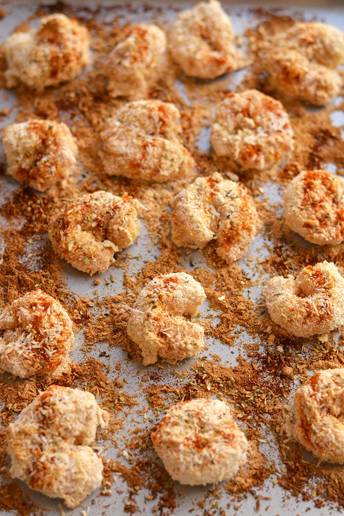 One Pan Baked Coconut Shrimp! Crispy, crunchy, spicy shrimp baked to perfection on a sheet pan. A "breaded" shrimp recipe that's healthy and grain free. Gluten Free + Low Calorie + Paleo