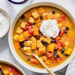Red chicken chili with sweet potatoes and butternut squash in a bowl.