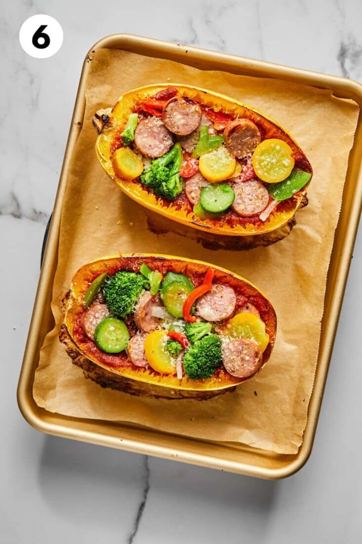 Cooked spaghetti squash pizza boats on a baking tray.