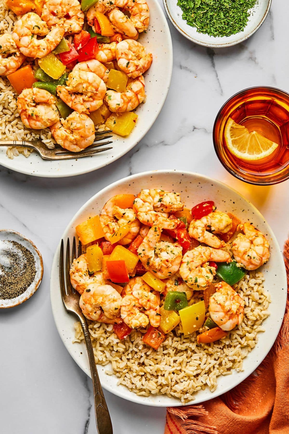 Shrimp and rice on a plate with a fork resting to the side.