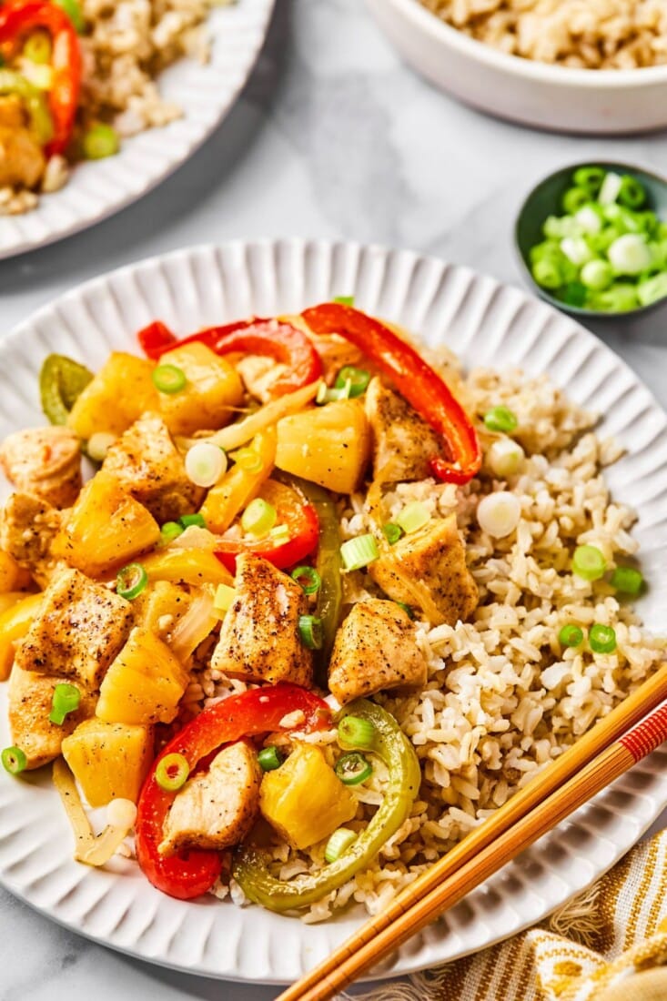 Low calorie sweet and sour chicken on a plate with more in the back. 