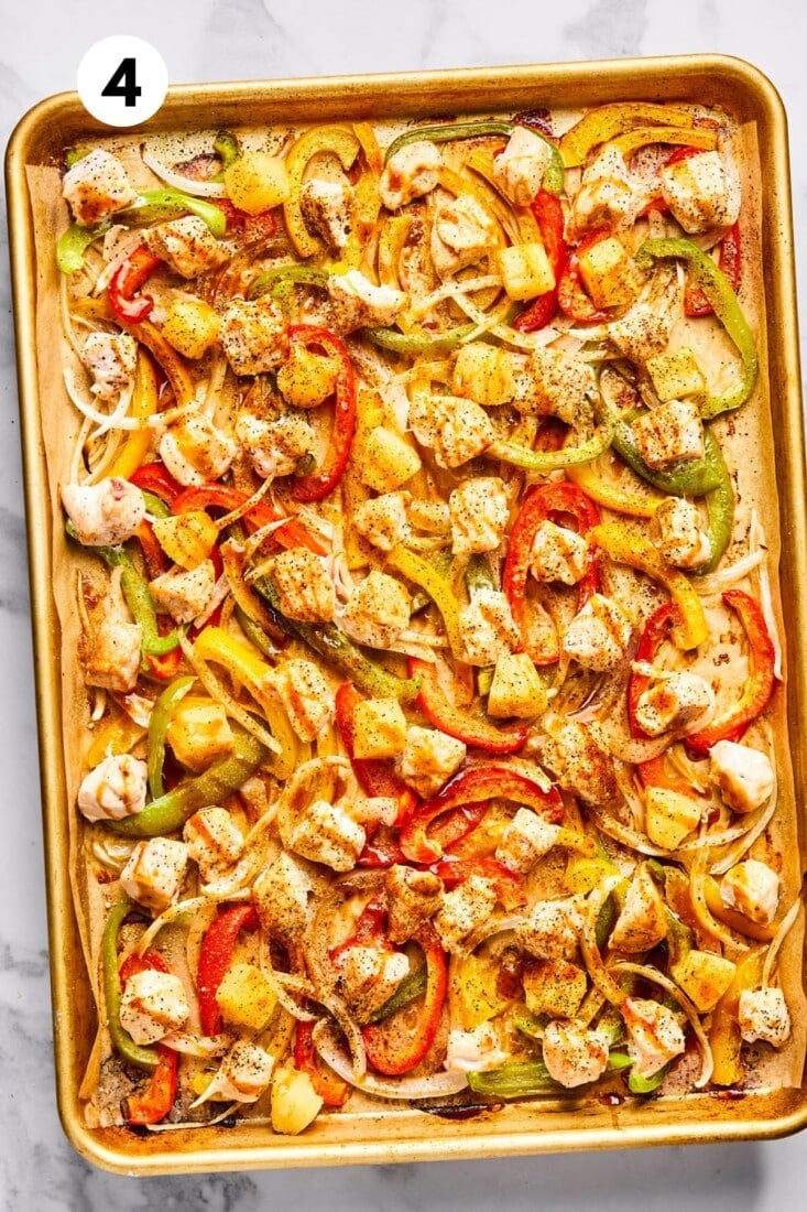 Sweet and sour chicken and vegetables spread out on a pan. 