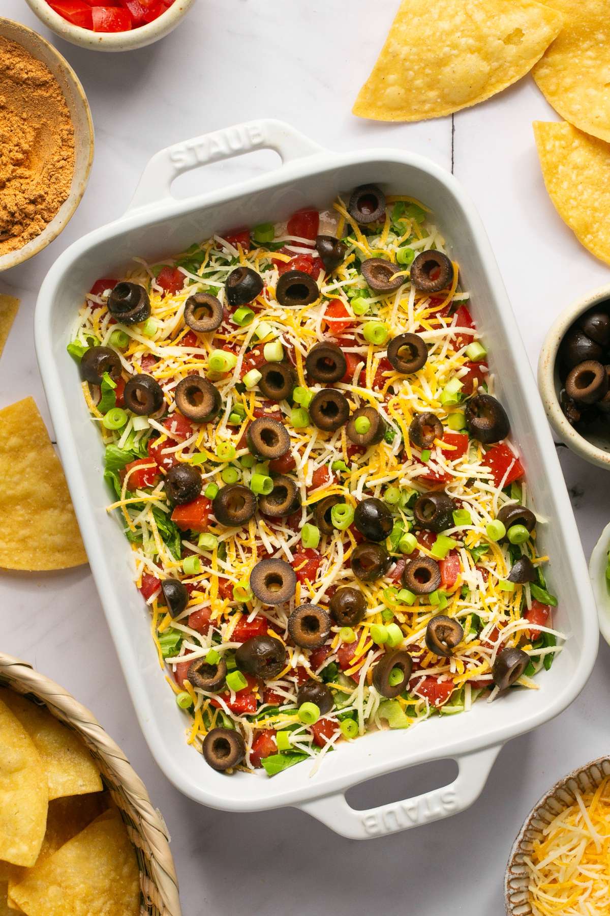 Healthy Taco Dip made with tangy, protein packed Greek Yogurt & homemade taco seasoning! Your guests will have no idea this flavorful party dip is healthy! Gluten Free + Low Calorie