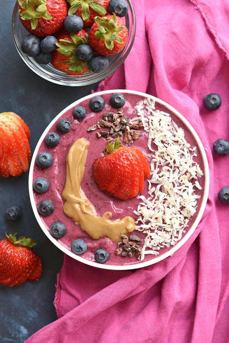 A tasty PB&J Superfood Smoothie made with acai, protein powder, fruit, nut butter, Greek yogurt & more! A vitamin & mineral packed breakfast or snack, resembling a favorite childhood sandwich. Gluten Free + Low Calorie!