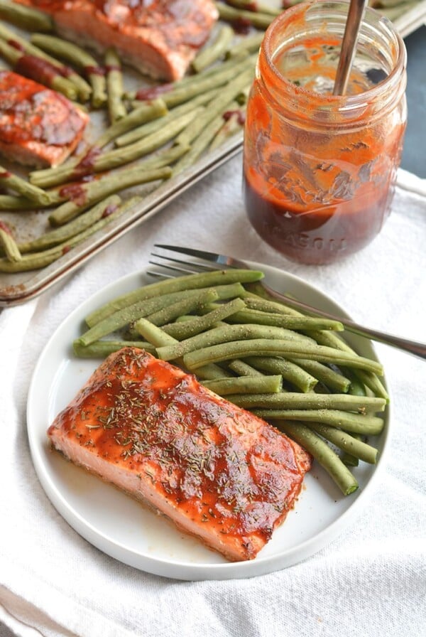 Low Sugar BBQ Salmon made on a sheet pan in less than 20 minutes. Low sugar BBQ sauce, thyme & green beans compliment the meal perfect. A hearty, yet healthy meal with simple good for you ingredients. Gluten Free + Low Calorie
