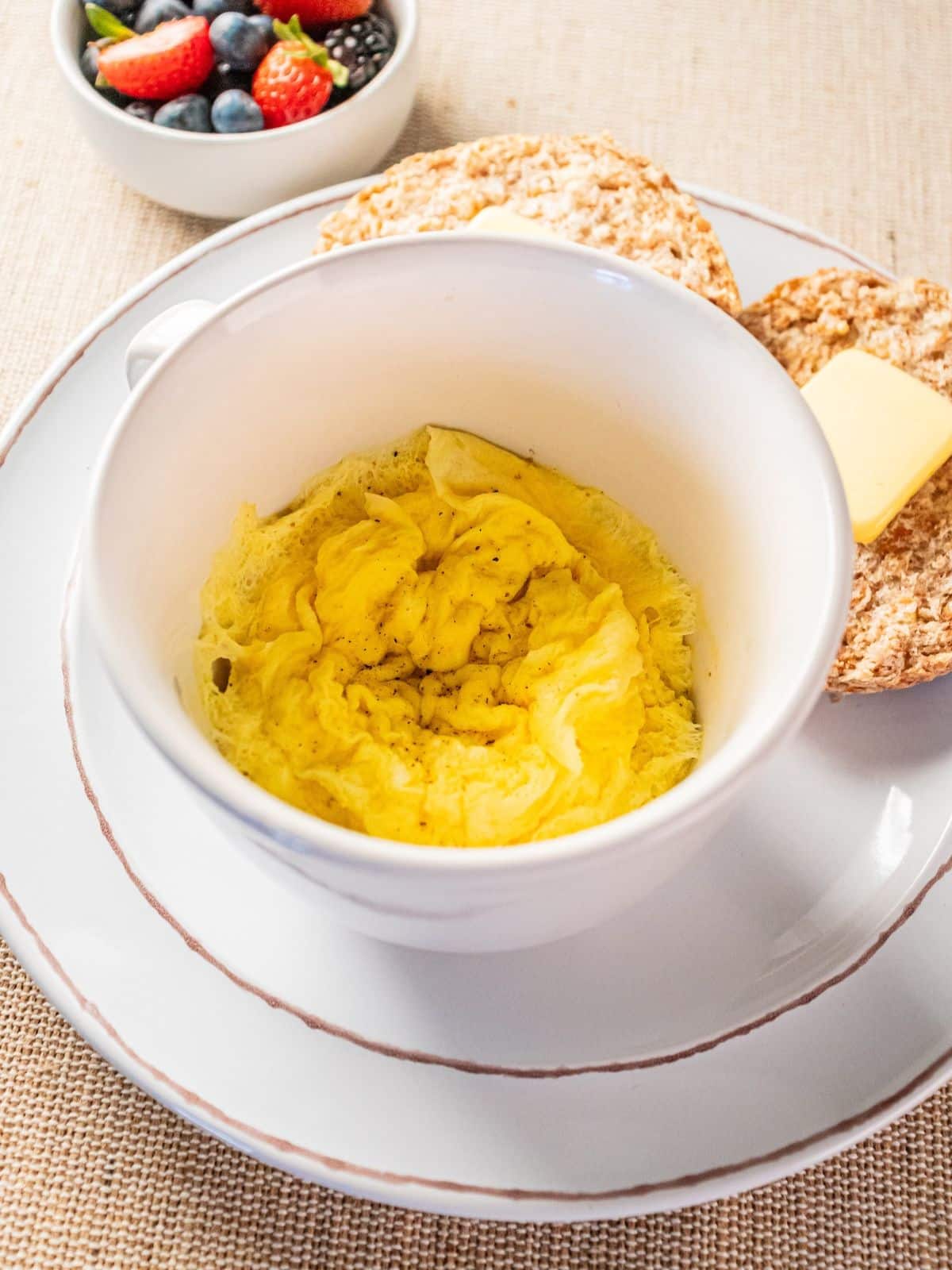 Microwave scrambled eggs in a mug on a plate.
