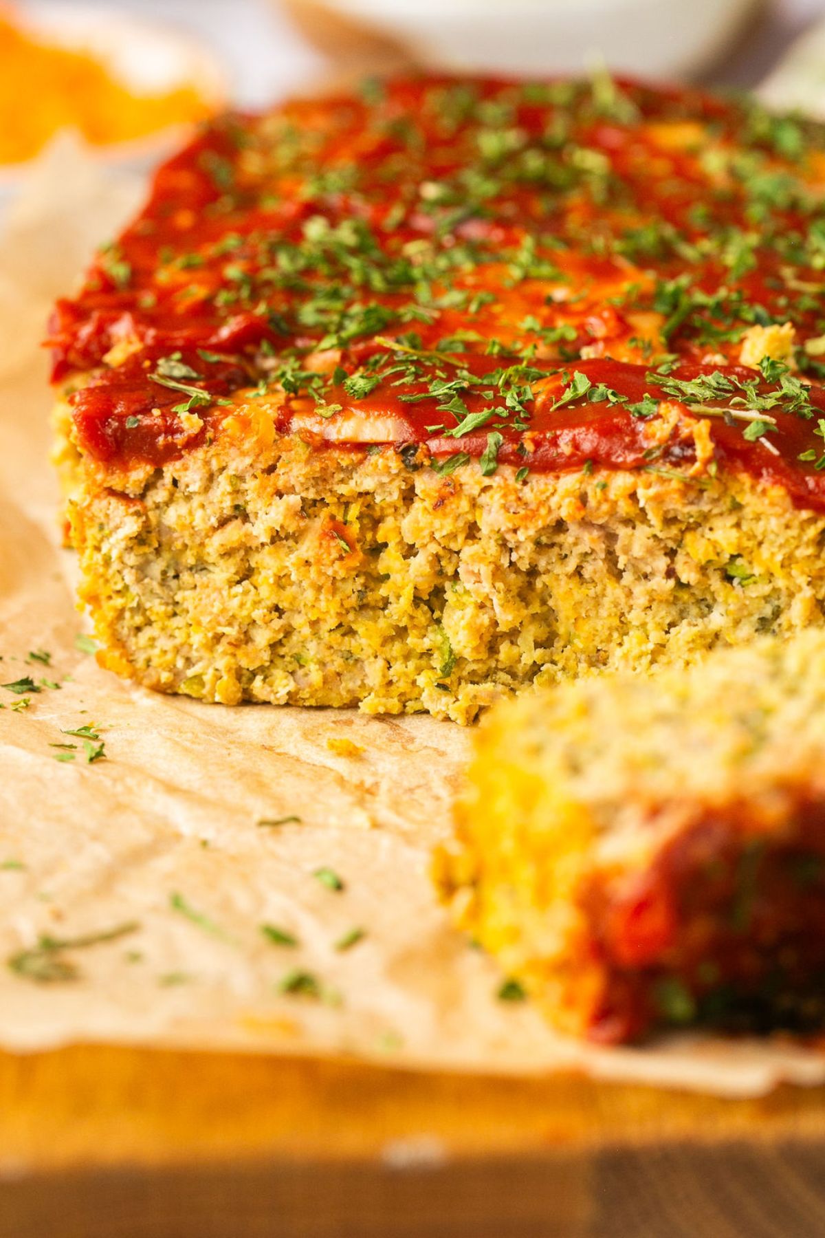 Gluten-free meatloaf cut to show the inside with a slice laying over in the front.