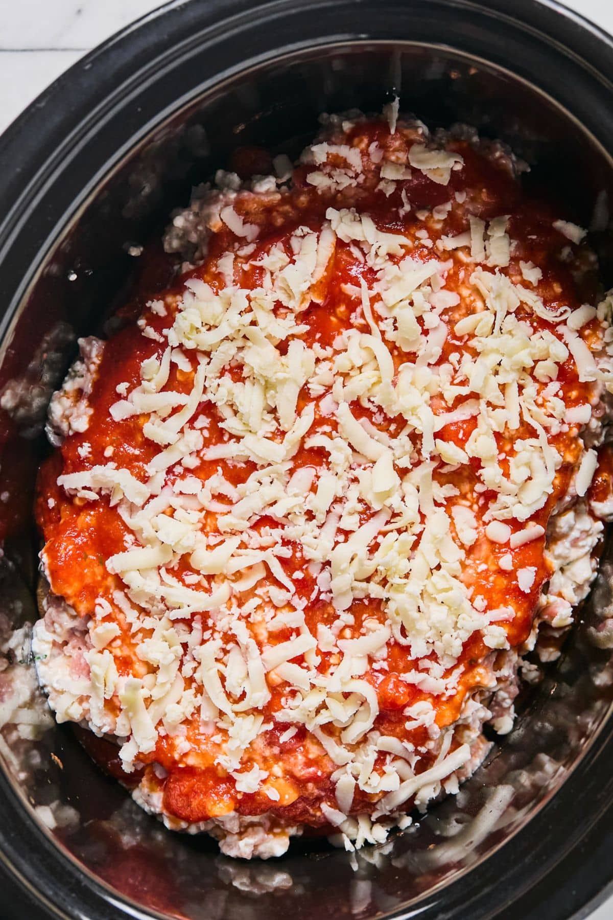 Mozzarella cheese added to the top of the lasagna.