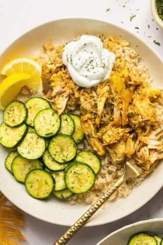 Slow cooker chicken shawarma in a bowl with rice and zucchini.