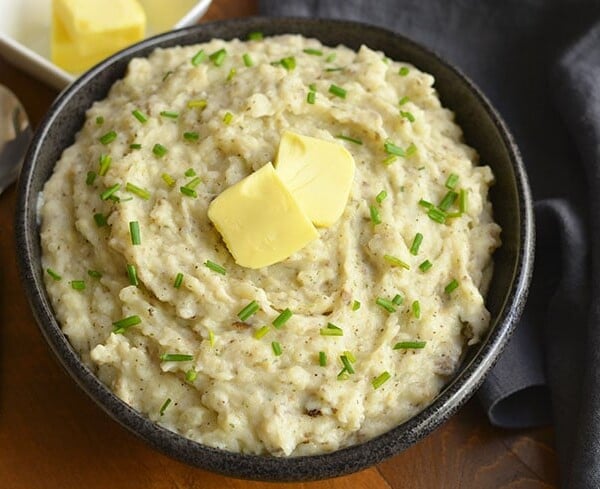 Healthier Mashed Potatoes & Cauliflower! This lighter version of the traditional dish adds cauliflower & Greek yogurt that no one will notice. A healthier side for your dinner table! Gluten Free + Low Calorie