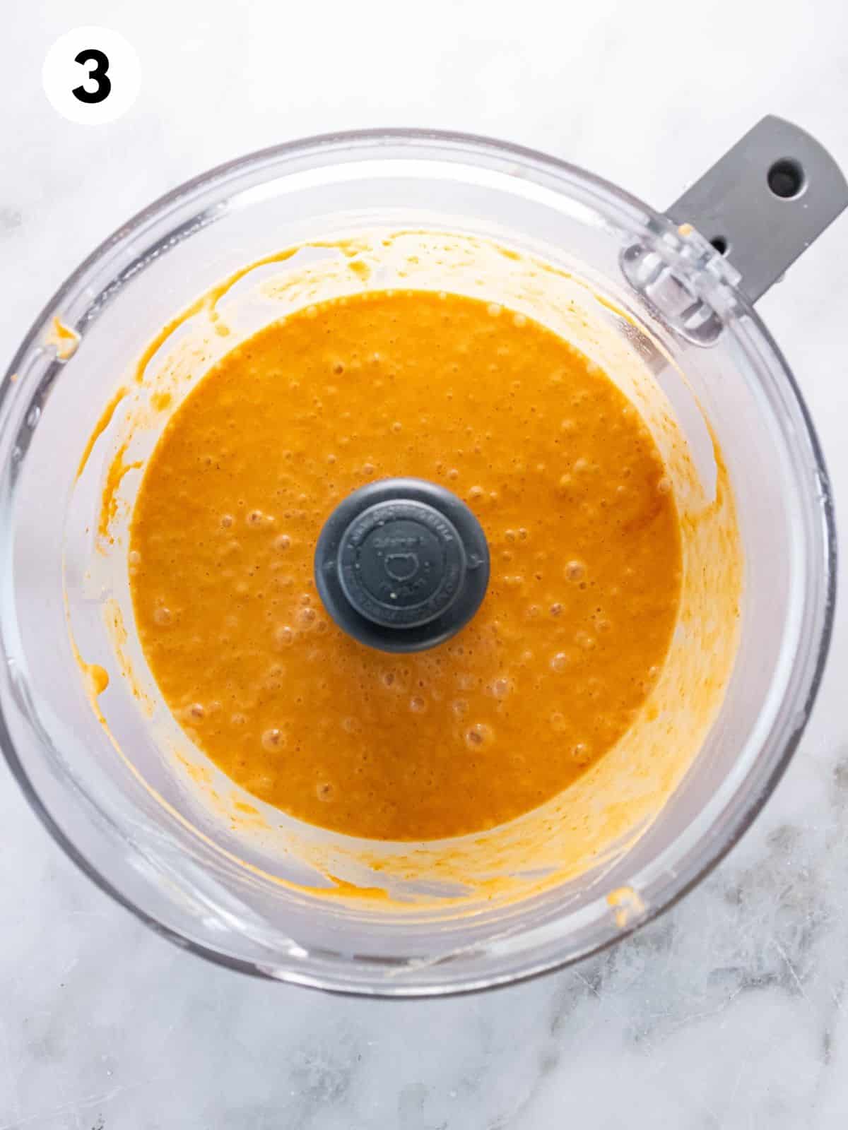 Pumpkin pie filling ingredients mixed together in a food processor.