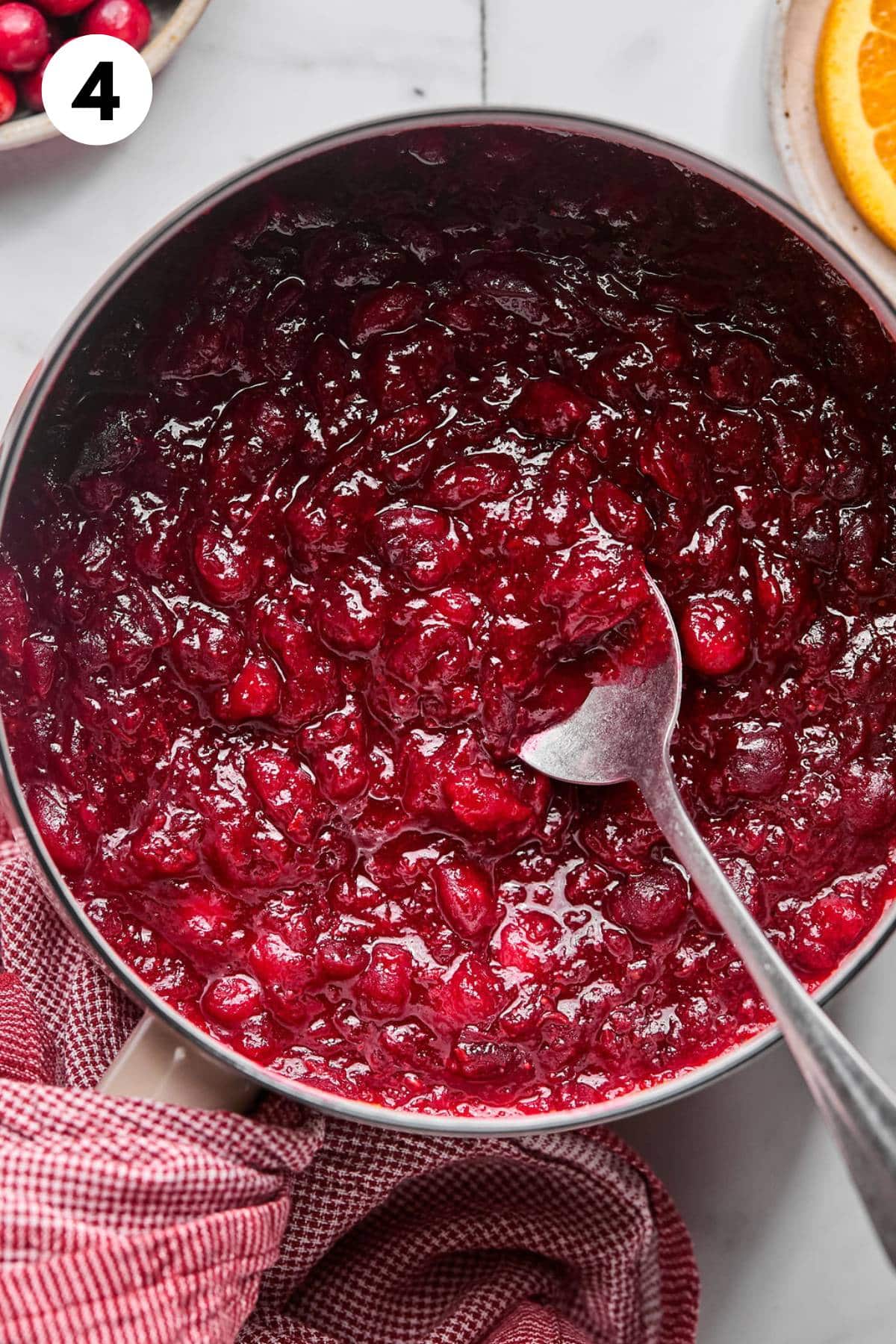 Sugar free cranberry sauce in a pot with a spoon after cooking.