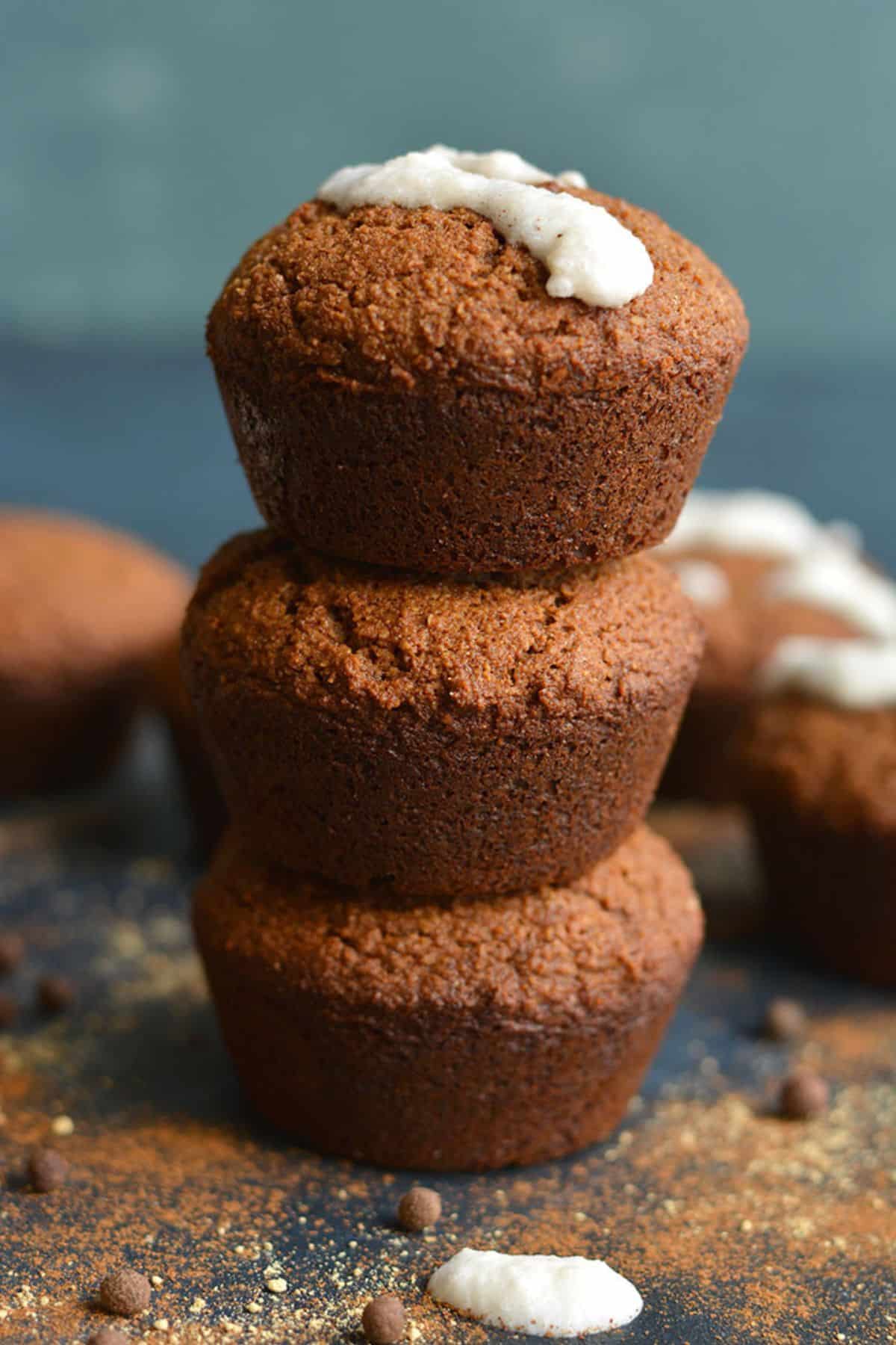Three healthy gingerbread muffins stacked up on one another.