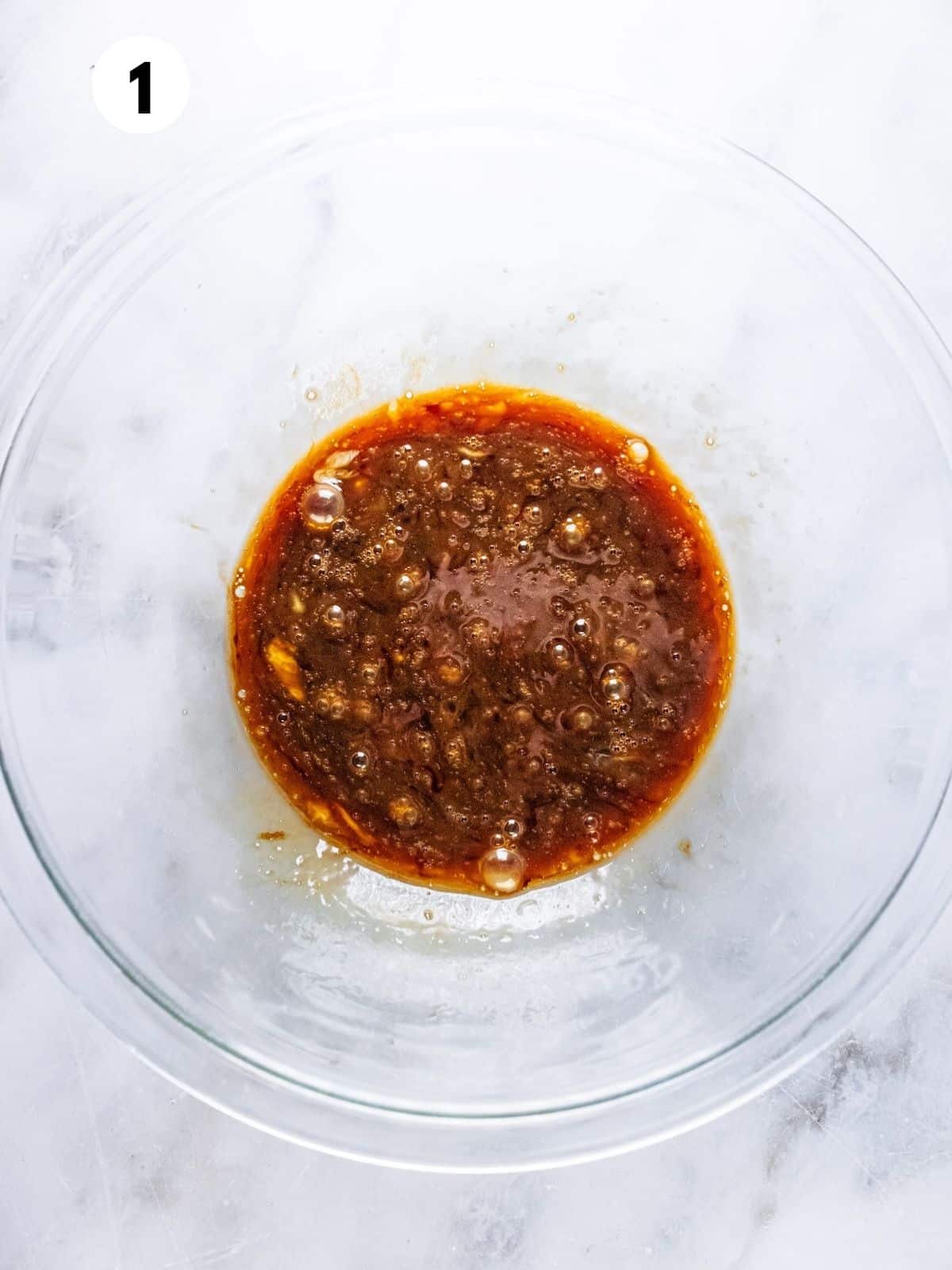 Wet ingredients mixed in a glass bowl.
