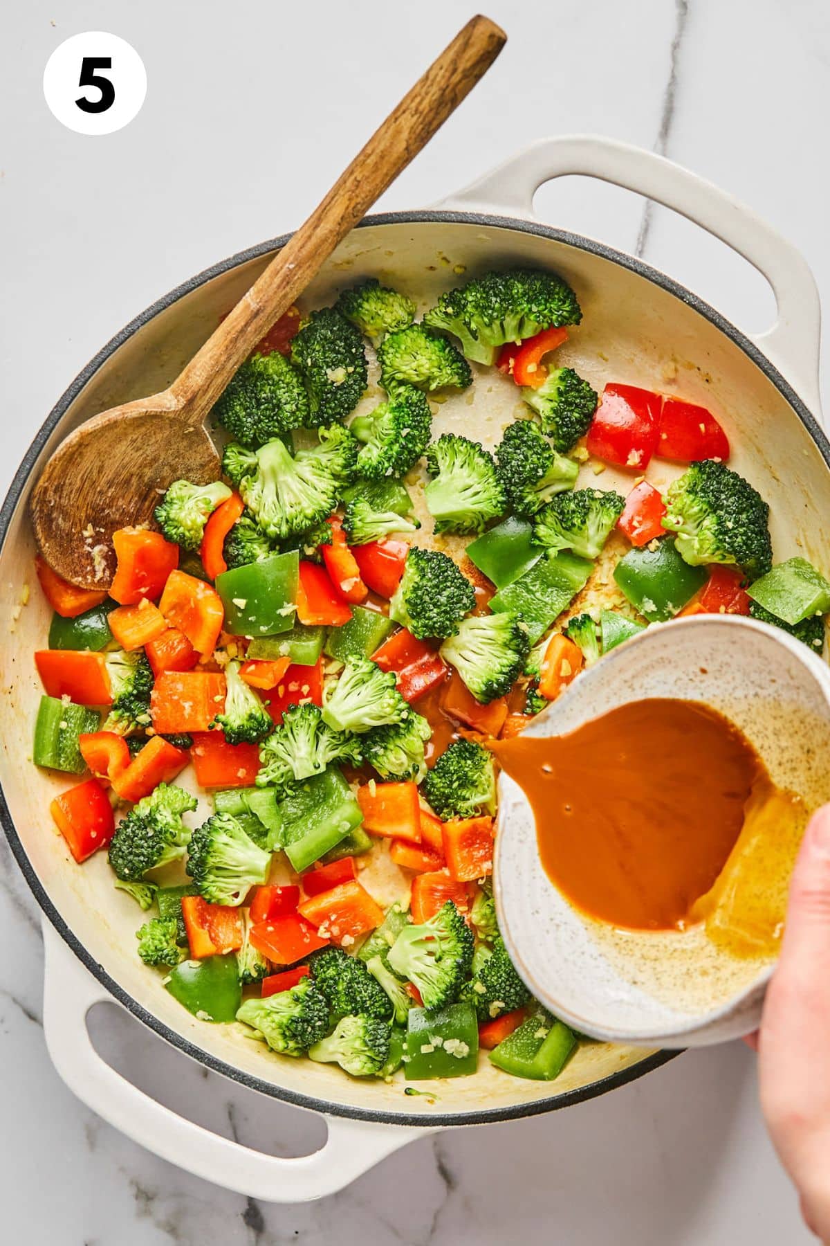 Chopped veggies and sauce in a skillet.