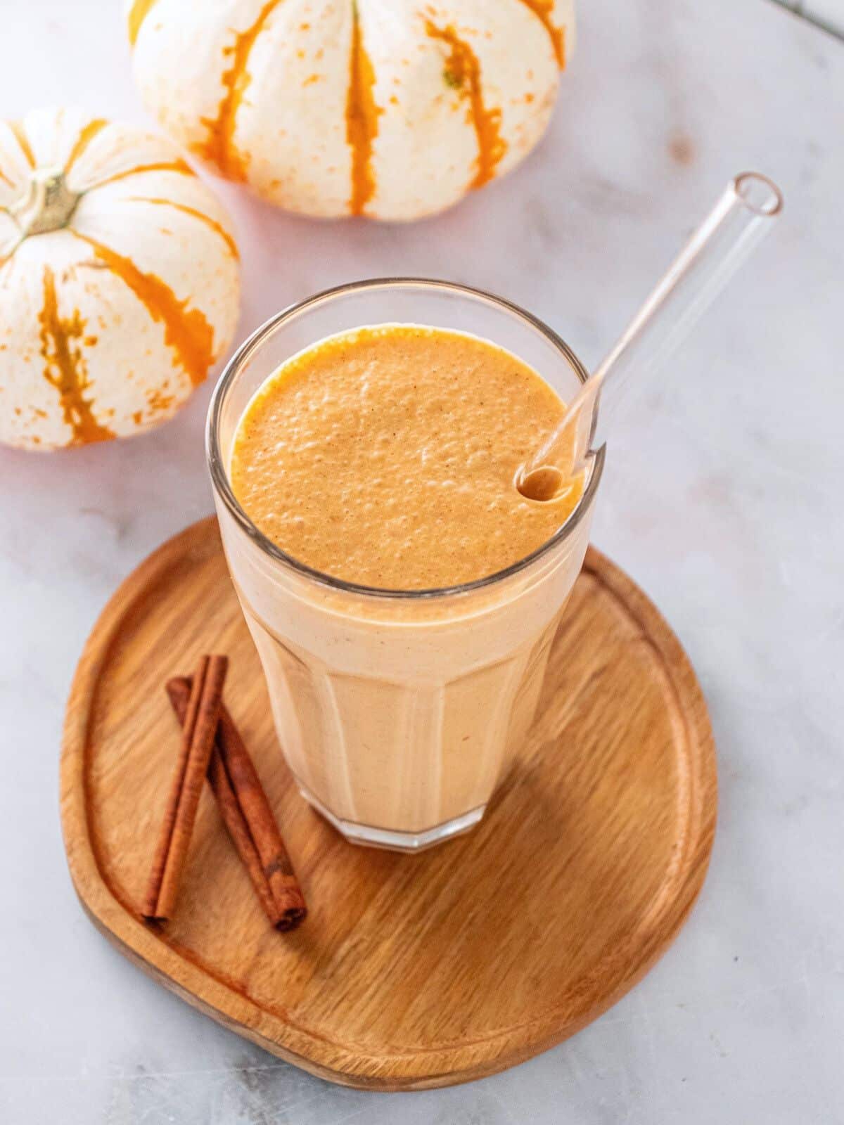 Gingerbread smoothie in a glass with a glass straw.
