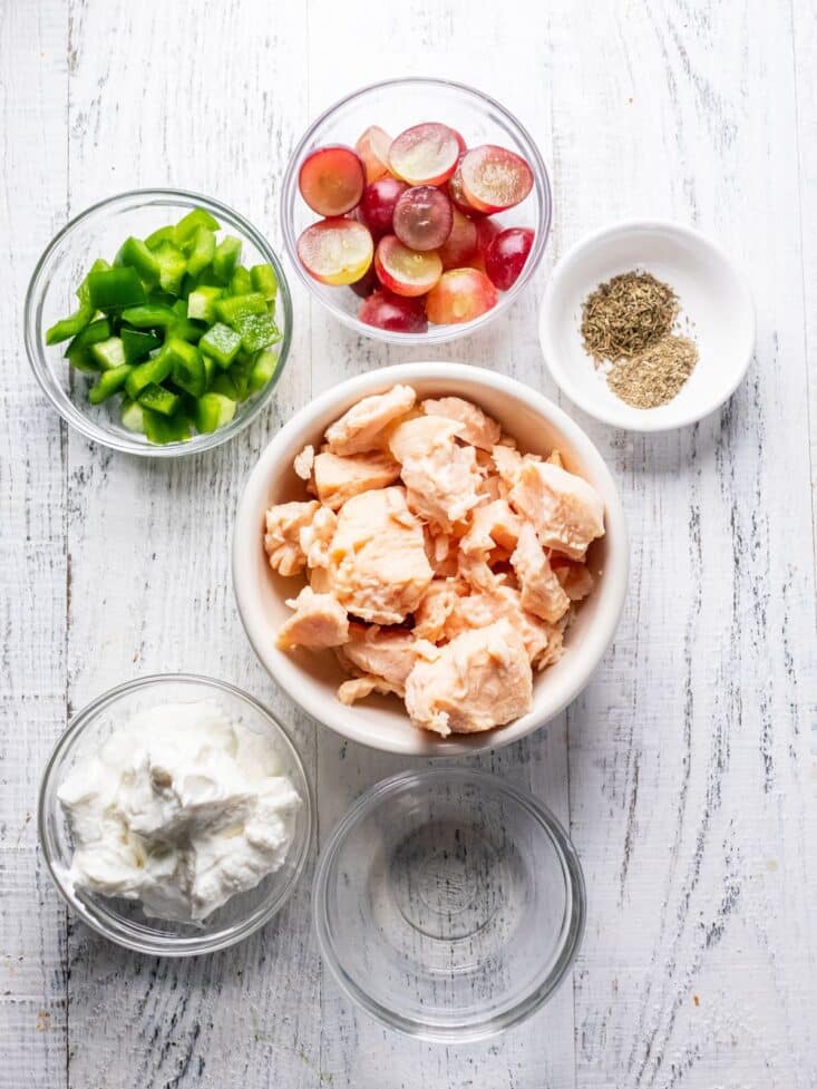 Ingredients to make healthy chicken salad on the table in bowls.