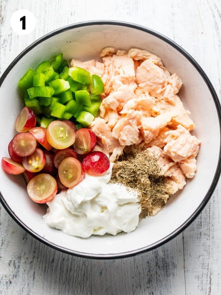 Ingredients to make high protein chicken salad in a bowl on the table.