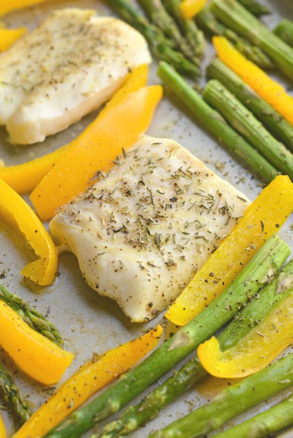 Sheet Pan Cod with Veggies! Baked cod with garlic & herbs with roasted veggies. A light, easy, Paleo meal that takes less than 30 minutes to make & prep. Baked cod never was so easy or so good! Gluten Free + Low Calorie + Paleo + Whole30