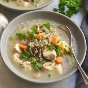 A bowl of chicken wild rice soup with a spoon in the bowl.