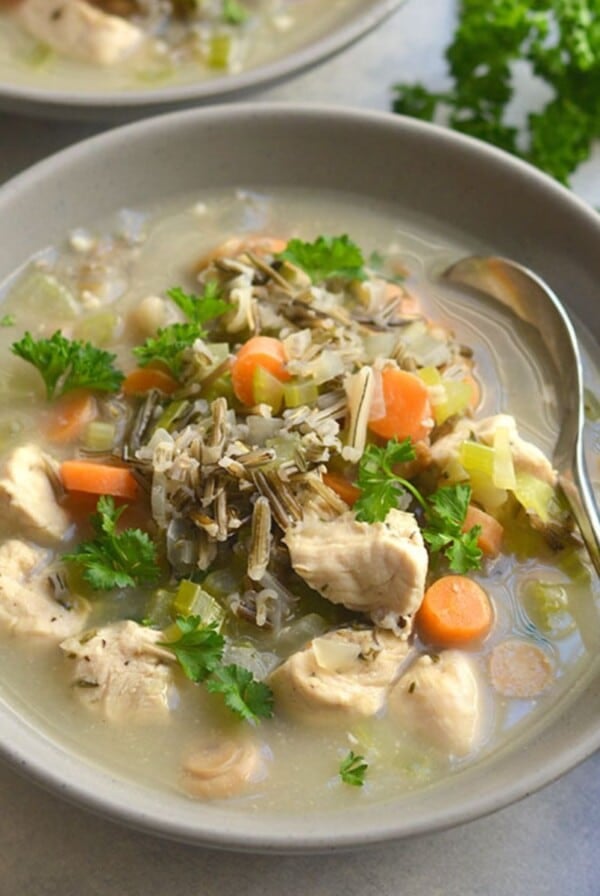 A bowl of chicken wild rice soup with a spoon in the bowl.