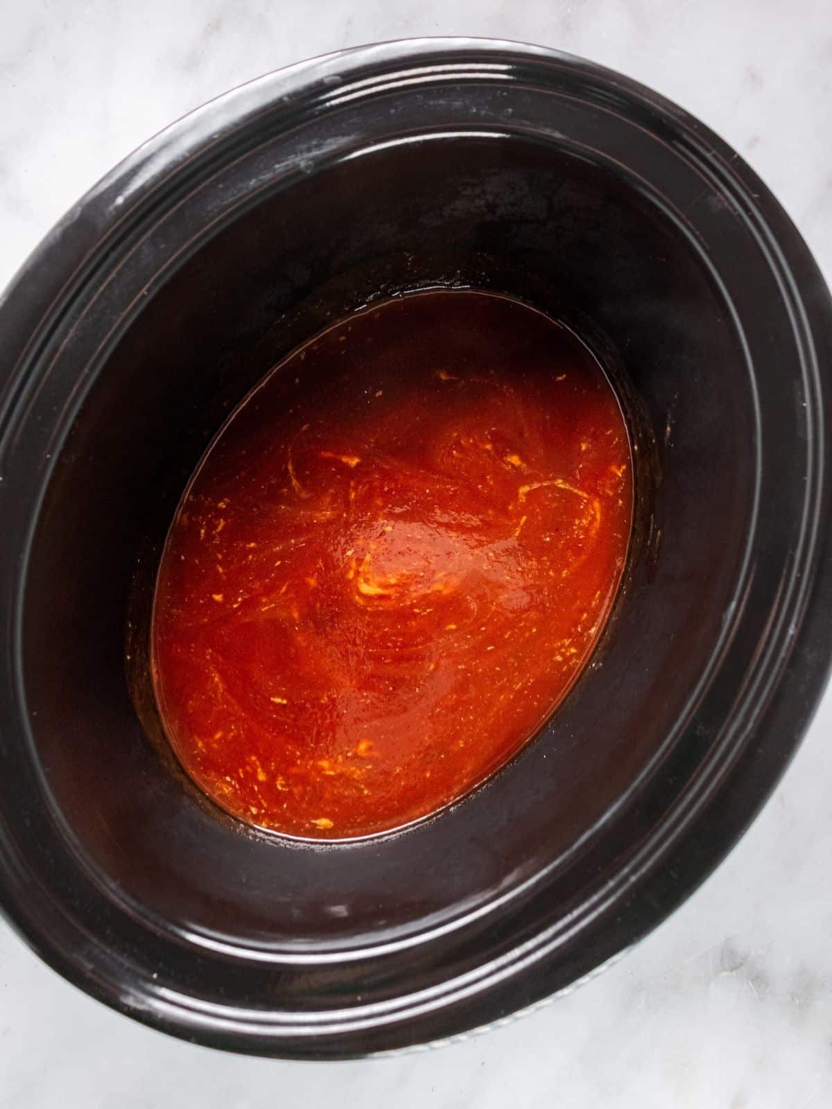 Sauce ingredients mixed together in a slow cooker.